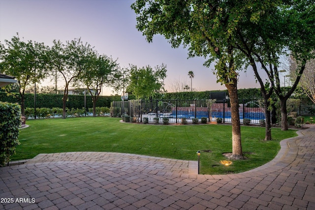 view of property's community with a pool, a yard, fence, and a patio area