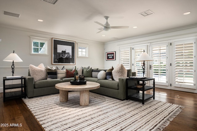 living room featuring a wealth of natural light, wood finished floors, and ornamental molding
