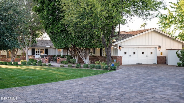 view of front of home featuring a garage, a front lawn, board and batten siding, and decorative driveway