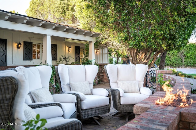 view of patio with an outdoor living space with a fire pit