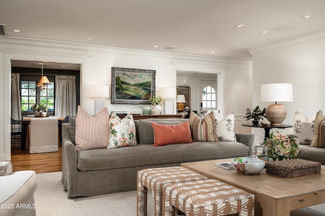 living room featuring light wood-style flooring, visible vents, crown molding, and recessed lighting