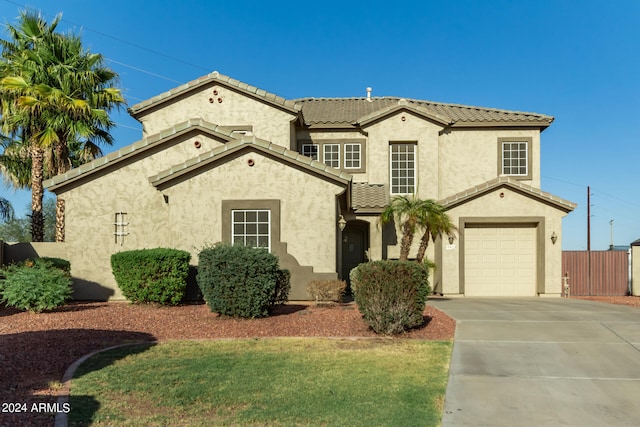 mediterranean / spanish-style home featuring a garage and a front yard