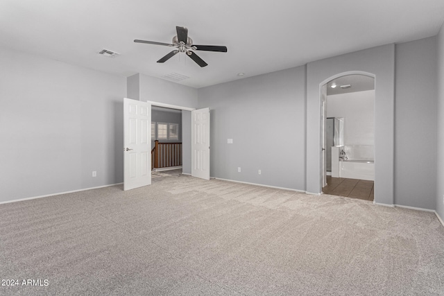 unfurnished bedroom featuring ceiling fan, carpet floors, and connected bathroom