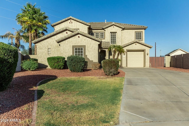 mediterranean / spanish-style home featuring a garage and a front yard