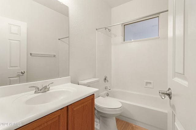 full bathroom with hardwood / wood-style floors, tub / shower combination, vanity, and toilet