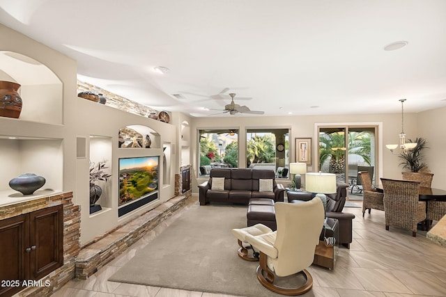 living area with built in features, visible vents, and a ceiling fan