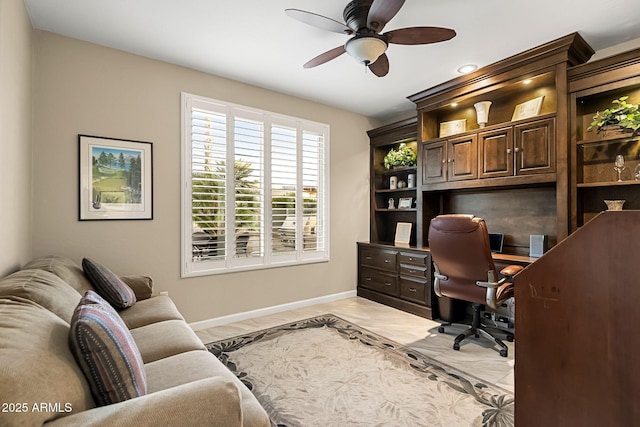 home office with a ceiling fan and baseboards