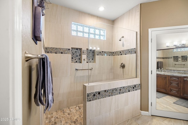 bathroom featuring walk in shower and vanity