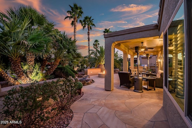 patio terrace at dusk featuring ceiling fan