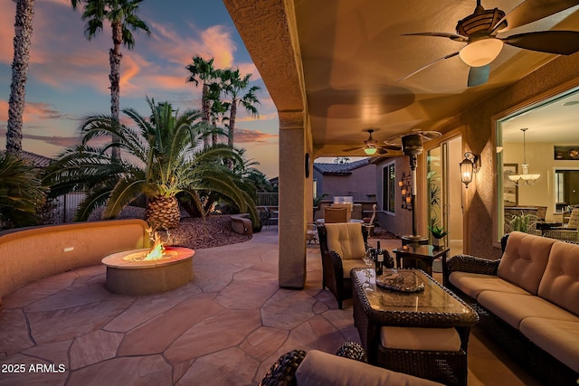 view of patio with an outdoor living space with a fire pit and a ceiling fan