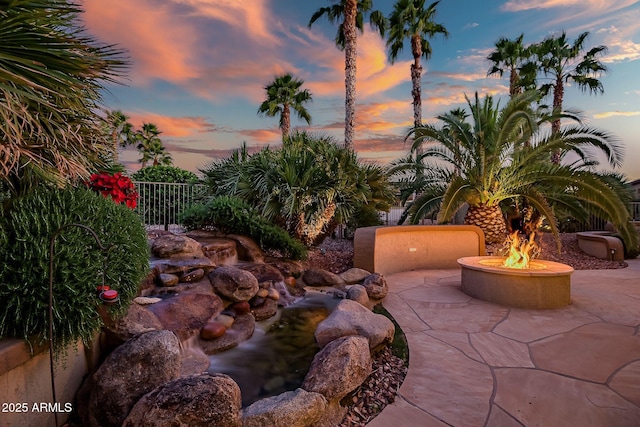 view of patio / terrace featuring an outdoor fire pit and fence