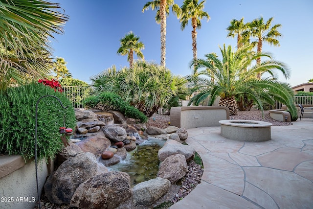 view of yard featuring a patio, fence, and an outdoor fire pit