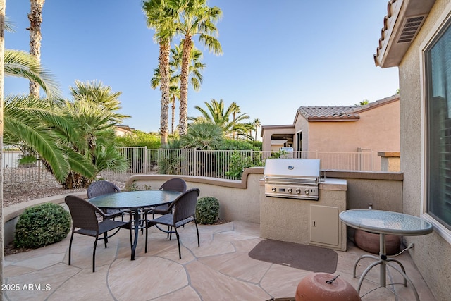 view of patio featuring grilling area, area for grilling, outdoor dining space, and fence