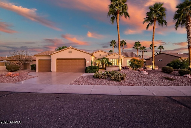 view of front of property featuring a garage, stucco siding, driveway, and a tiled roof