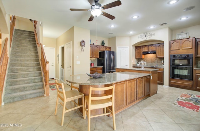 708 E Dry Creek Rd, San Tan Valley, AZ 85143 - kitchen featuring black appliances, a center island with sink, decorative backsplash, light tile patterned floors, and recessed lighting