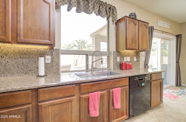 708 E Dry Creek Rd, San Tan Valley, AZ 85143 - kitchen featuring black dishwasher, decorative backsplash, light stone counters, brown cabinets, and light tile patterned floors