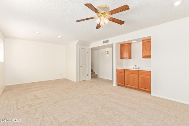 unfurnished room with light carpet, stairs, visible vents, and a textured ceiling