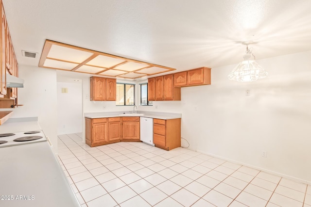 kitchen with light countertops, visible vents, a sink, dishwasher, and under cabinet range hood