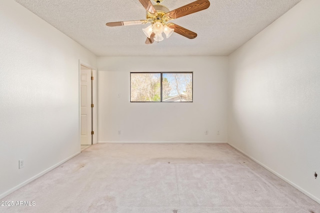 spare room with carpet floors, a textured ceiling, baseboards, and a ceiling fan