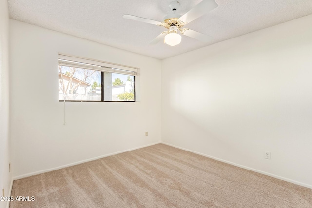 unfurnished room with a ceiling fan, carpet, baseboards, and a textured ceiling