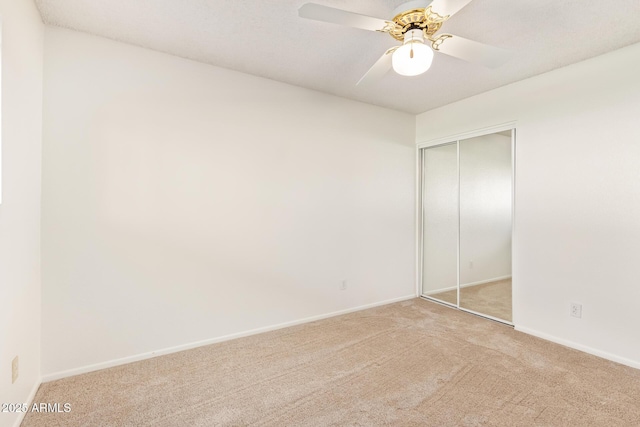 unfurnished bedroom featuring carpet floors, a closet, ceiling fan, and baseboards