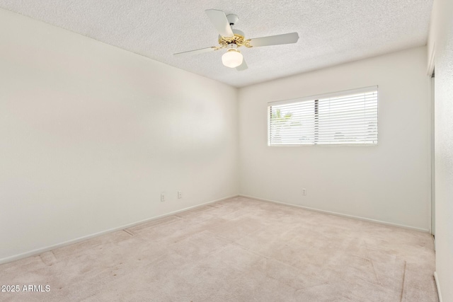 unfurnished room with a ceiling fan, light colored carpet, a textured ceiling, and baseboards