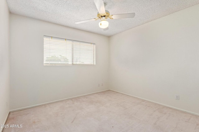 unfurnished room featuring carpet flooring, ceiling fan, a textured ceiling, and baseboards