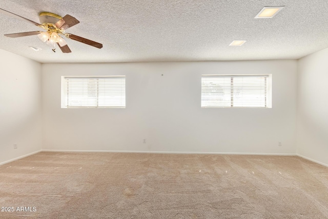 unfurnished room with a ceiling fan, carpet flooring, a textured ceiling, and baseboards