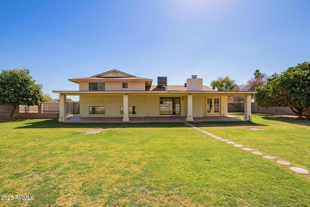 rear view of property with french doors, a patio area, a yard, and a fenced backyard