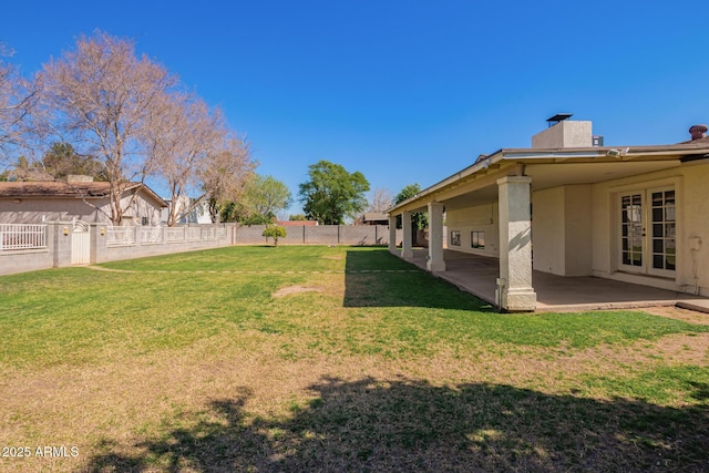 view of yard featuring french doors, a patio area, and a fenced backyard