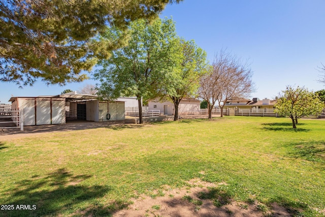 view of yard featuring fence and an outbuilding