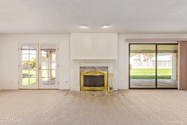 unfurnished living room featuring a premium fireplace, carpet flooring, and a healthy amount of sunlight