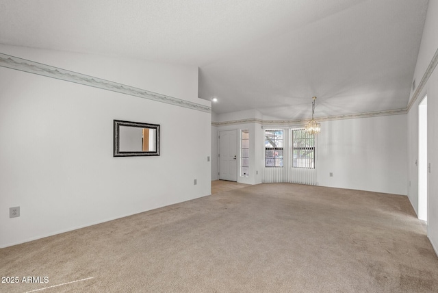 carpeted empty room featuring a notable chandelier and lofted ceiling