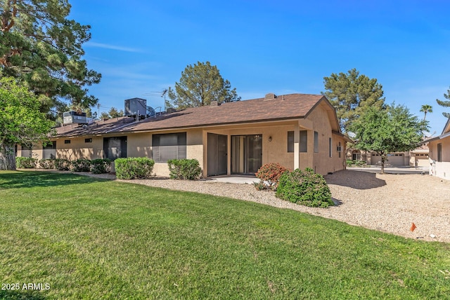 back of property featuring a yard, stucco siding, and fence