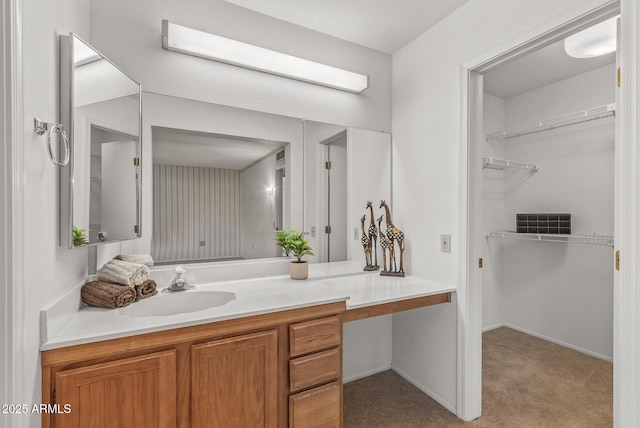 bathroom with a spacious closet and vanity