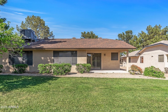 back of house with a shingled roof, stucco siding, cooling unit, and a lawn