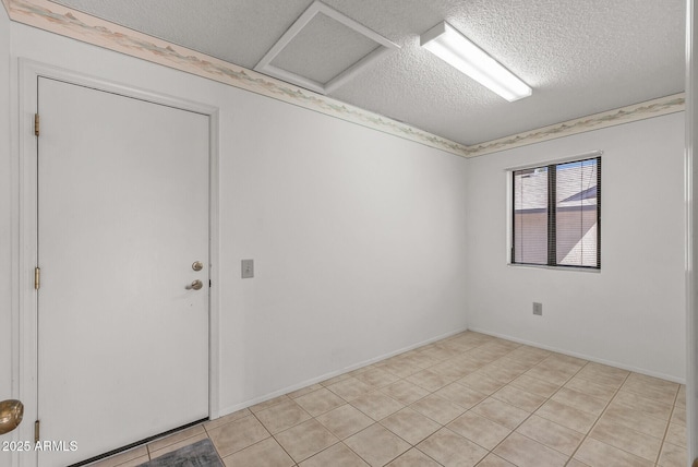 unfurnished room featuring light tile patterned floors and a textured ceiling