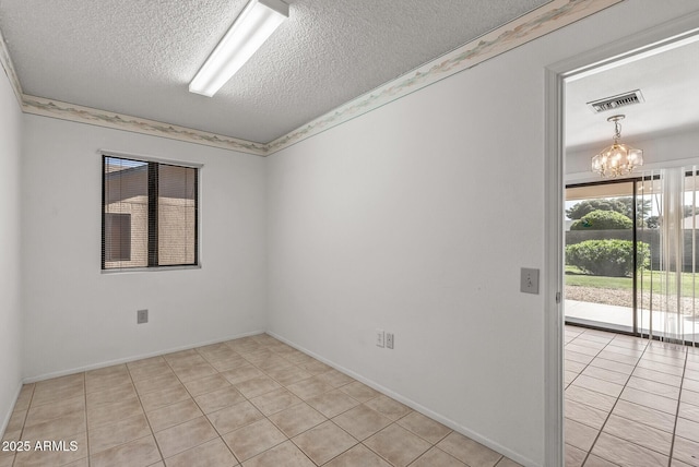 empty room with visible vents, light tile patterned flooring, a notable chandelier, and a textured ceiling