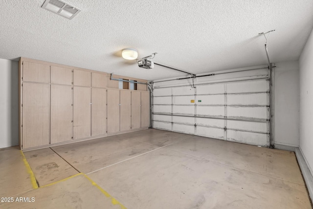 garage featuring visible vents and a garage door opener