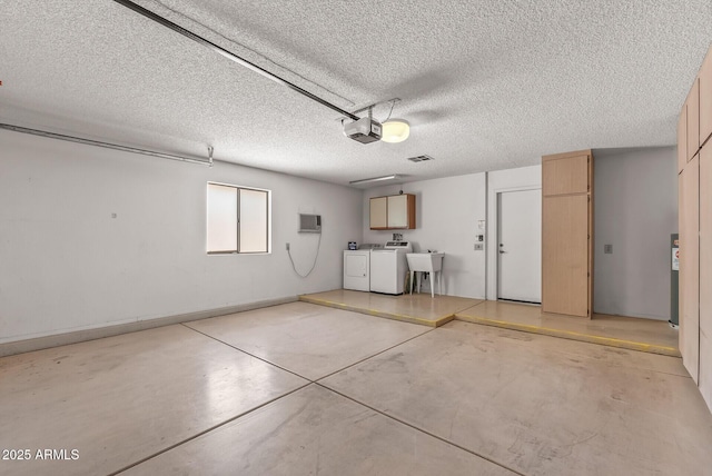 garage with a sink, visible vents, independent washer and dryer, and a garage door opener