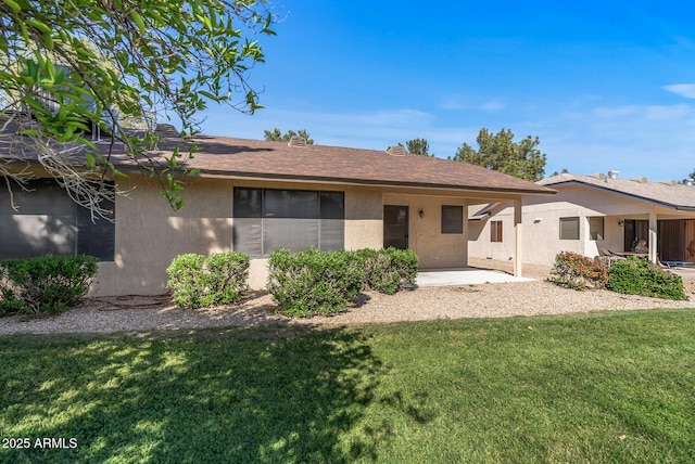 back of property with a patio, stucco siding, and a lawn