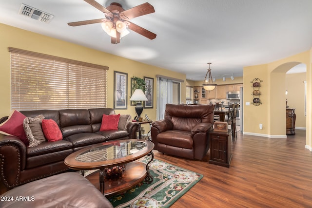 living room with dark hardwood / wood-style floors and ceiling fan