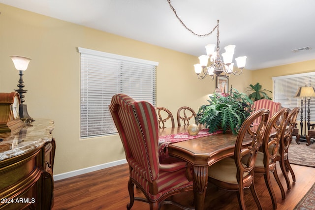 dining space featuring dark hardwood / wood-style flooring and an inviting chandelier