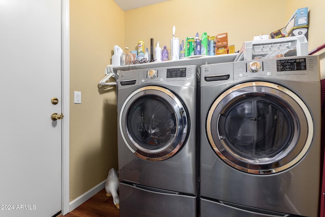 laundry area featuring washing machine and dryer and hardwood / wood-style flooring