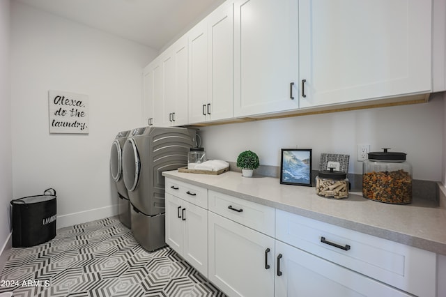 laundry area featuring cabinets, light tile patterned floors, and washer and dryer