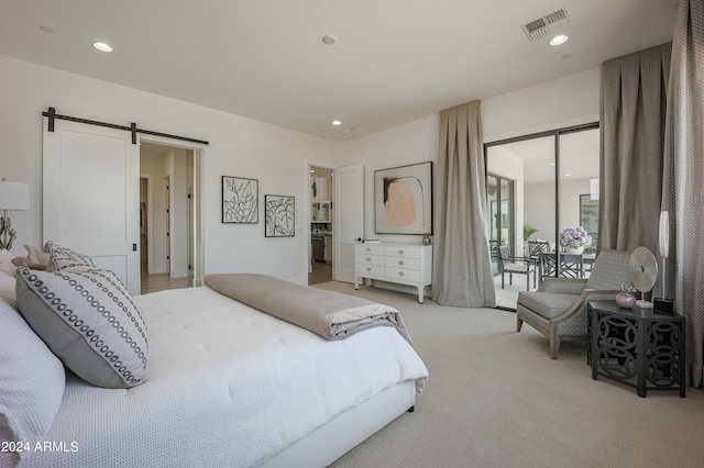 bedroom with a barn door and light colored carpet