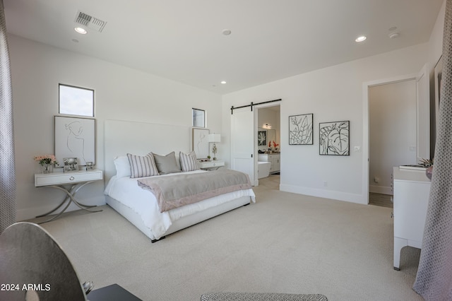 bedroom featuring a barn door and light colored carpet