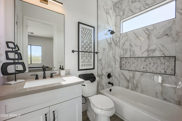 full bathroom with toilet, vanity, and tiled shower / bath combo