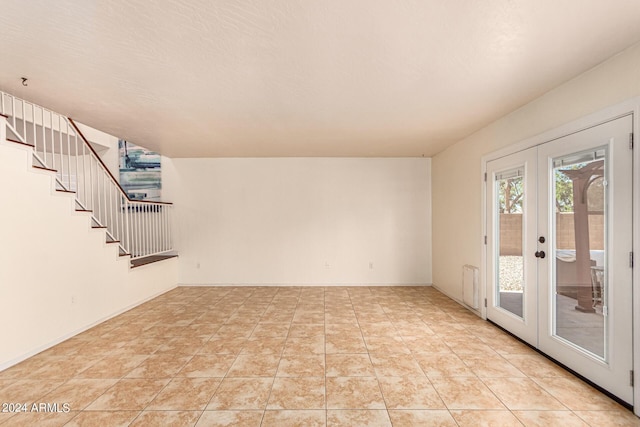 unfurnished room featuring light tile patterned floors, french doors, and radiator heating unit