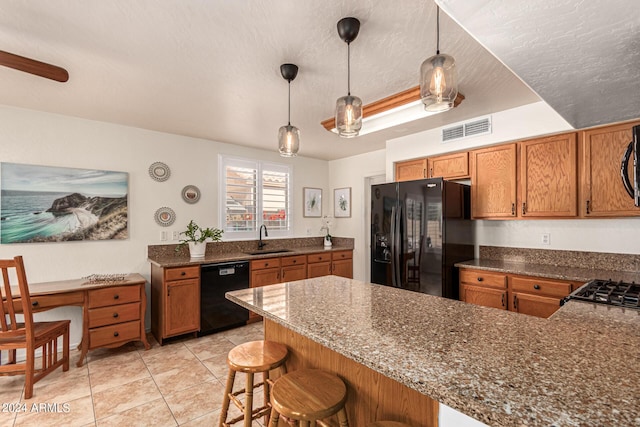 kitchen featuring black appliances, a breakfast bar, kitchen peninsula, and pendant lighting